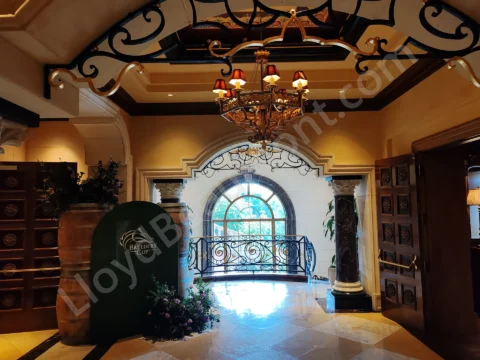 Warmly lit event foyer with ornate railings and a Breeders' Cup display.