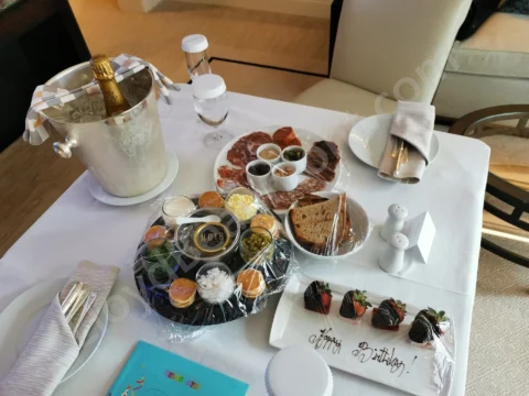Champagne, caviar, and chocolate-covered strawberries arranged for a hotel-room birthday celebration.