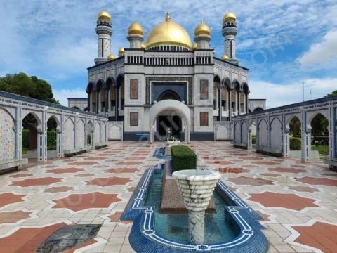 Golden-domed mosque with a symmetrical courtyard, patterned arcades, and fountains.